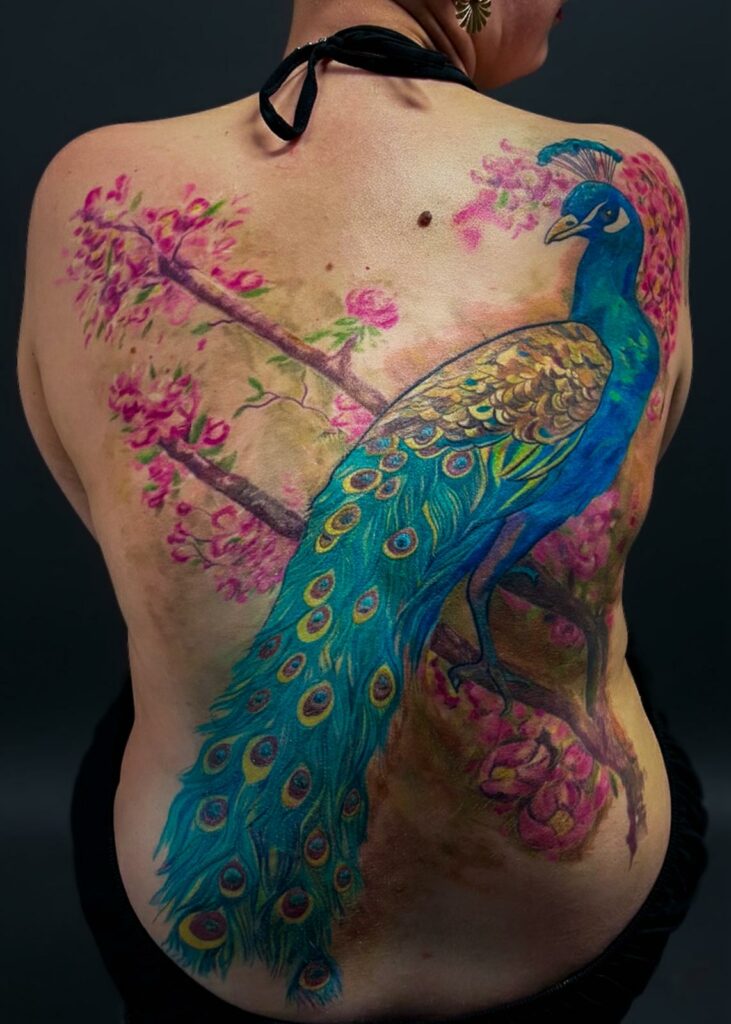 Tatouage de paon en couleur dans le dos réalisé par Tamara Chaudesaigues